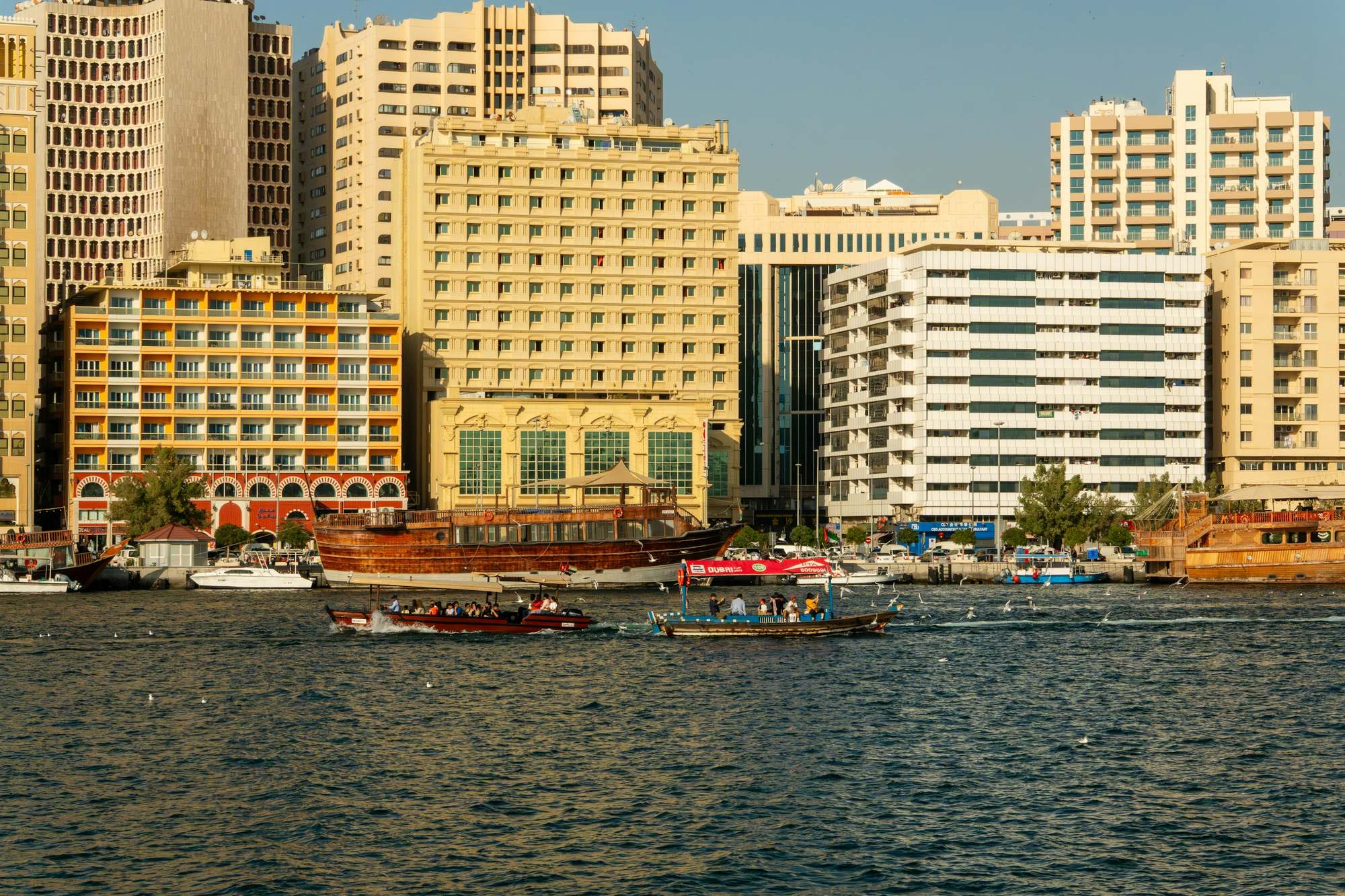 Wooden dhows moored along Dubai Creek in front of the Deira waterfront