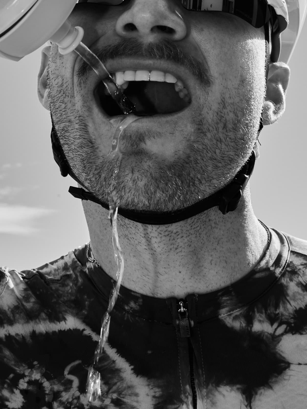 A cyclist drinking from a soft flask mid-ride