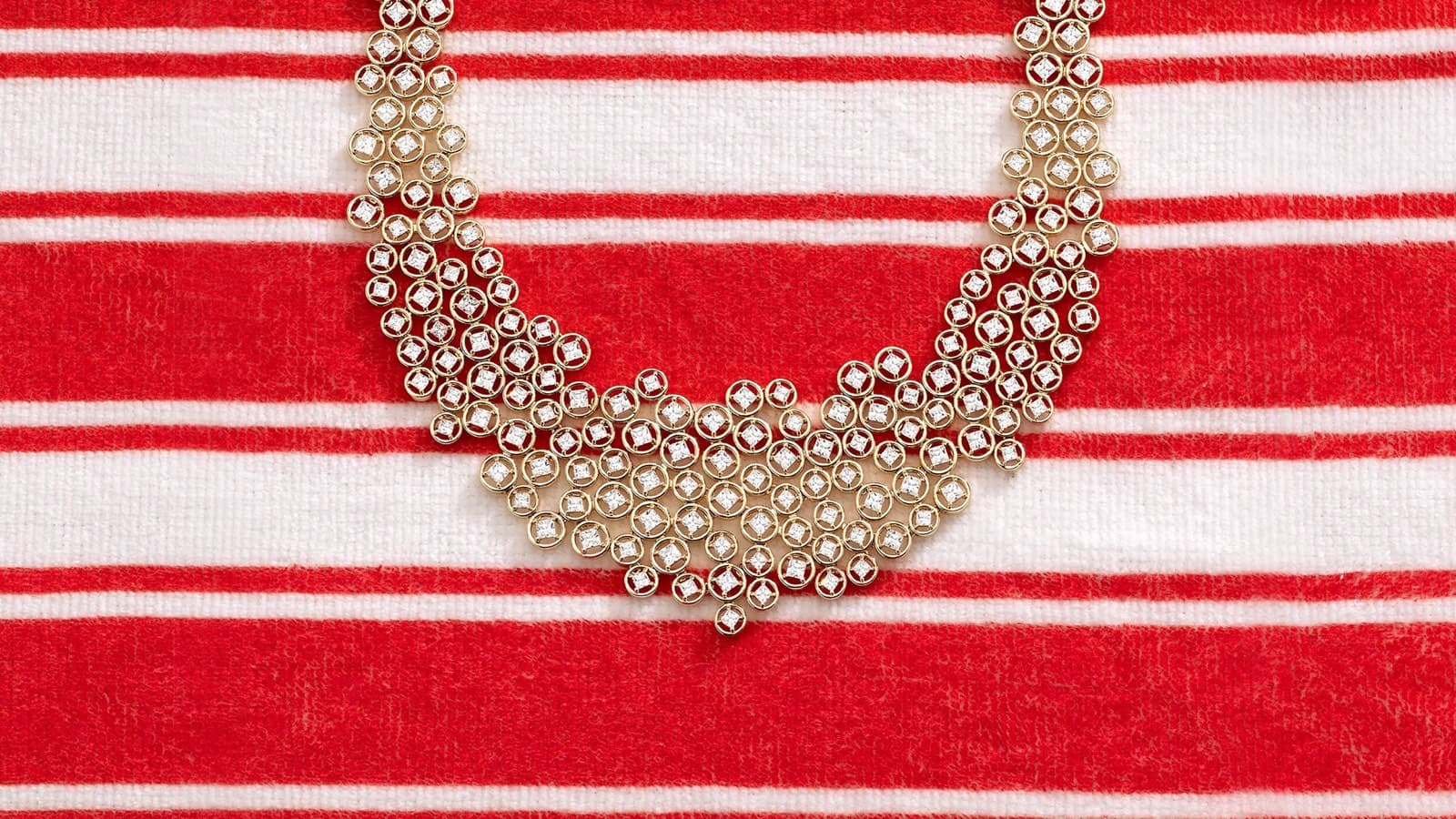 APM Monaco necklace from the Été collection on a striped beach towel