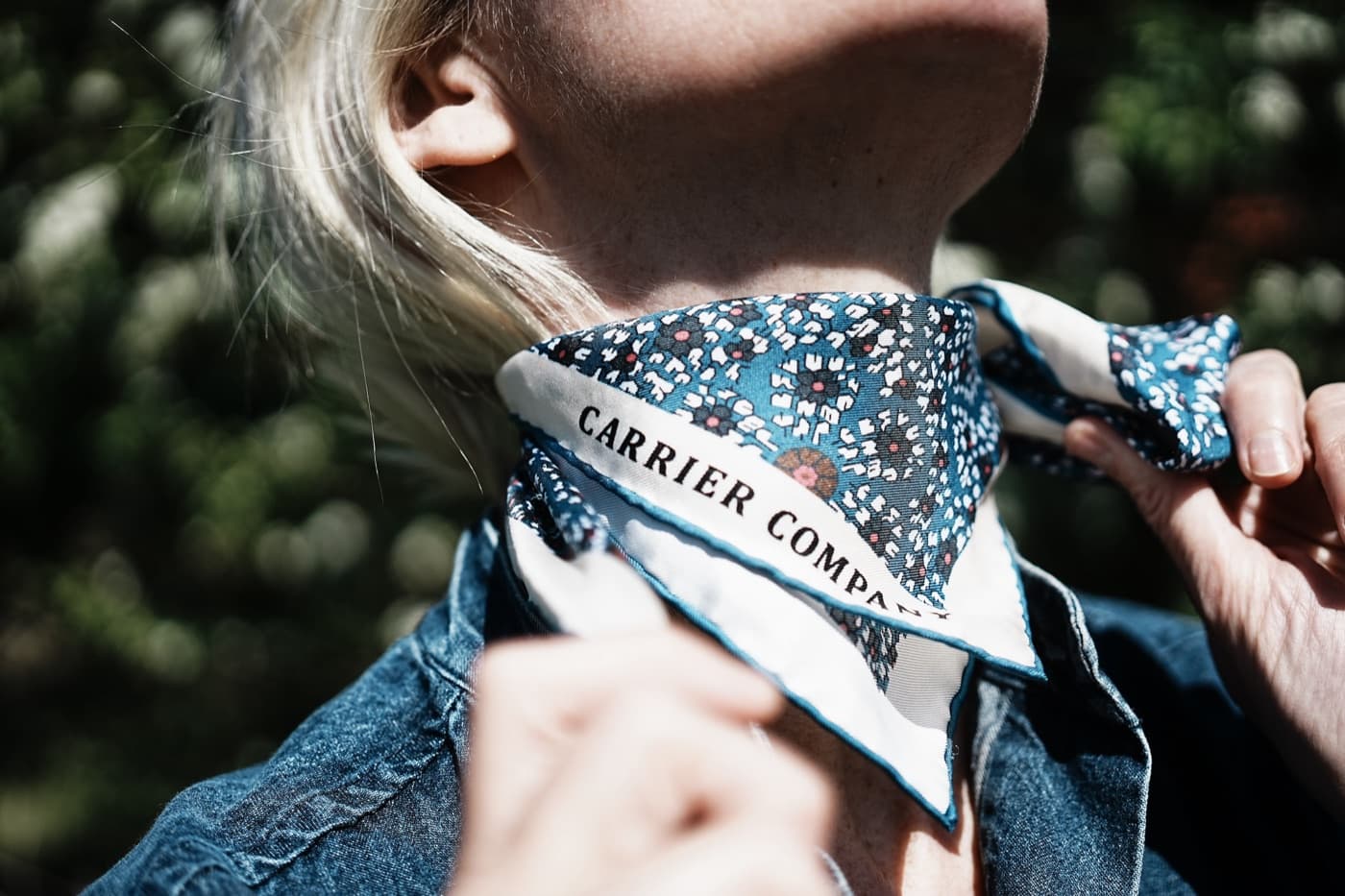 A Carrier Company silk neck scarf, branded and tied outdoors