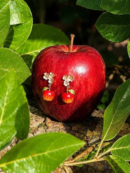 Fable England apple charm earrings styled on a real apple