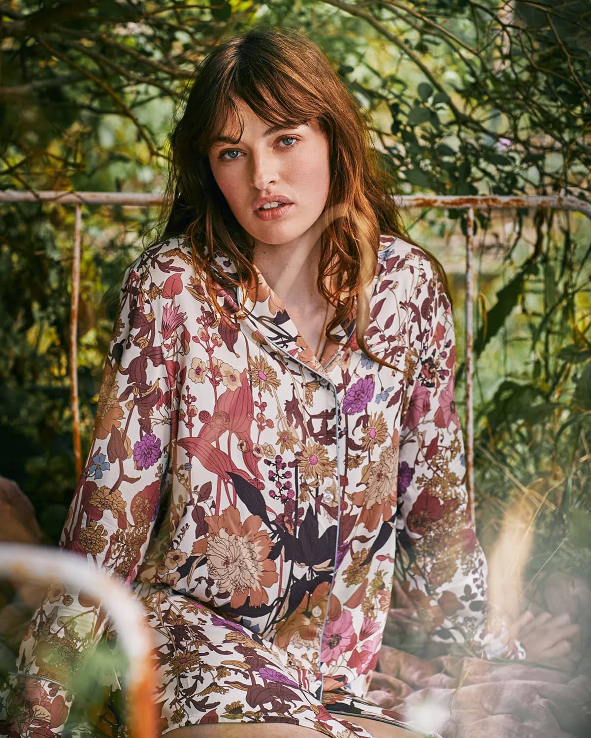 A model in a Fable England hand-painted floral pyjama set, photographed in a garden