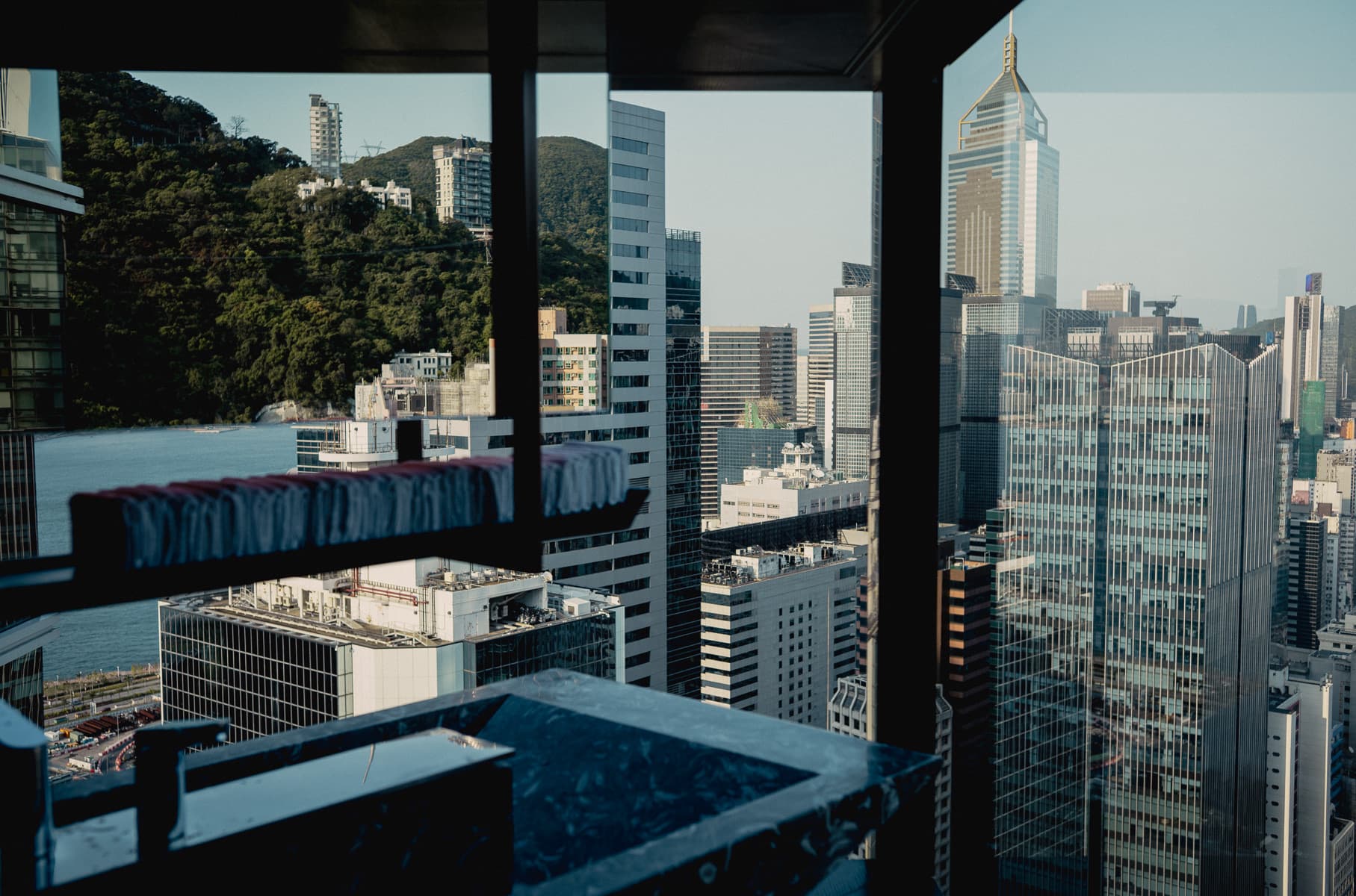 Hong Kong Island from a high-rise window, the Mid-Levels hillside behind the Wan Chai towers