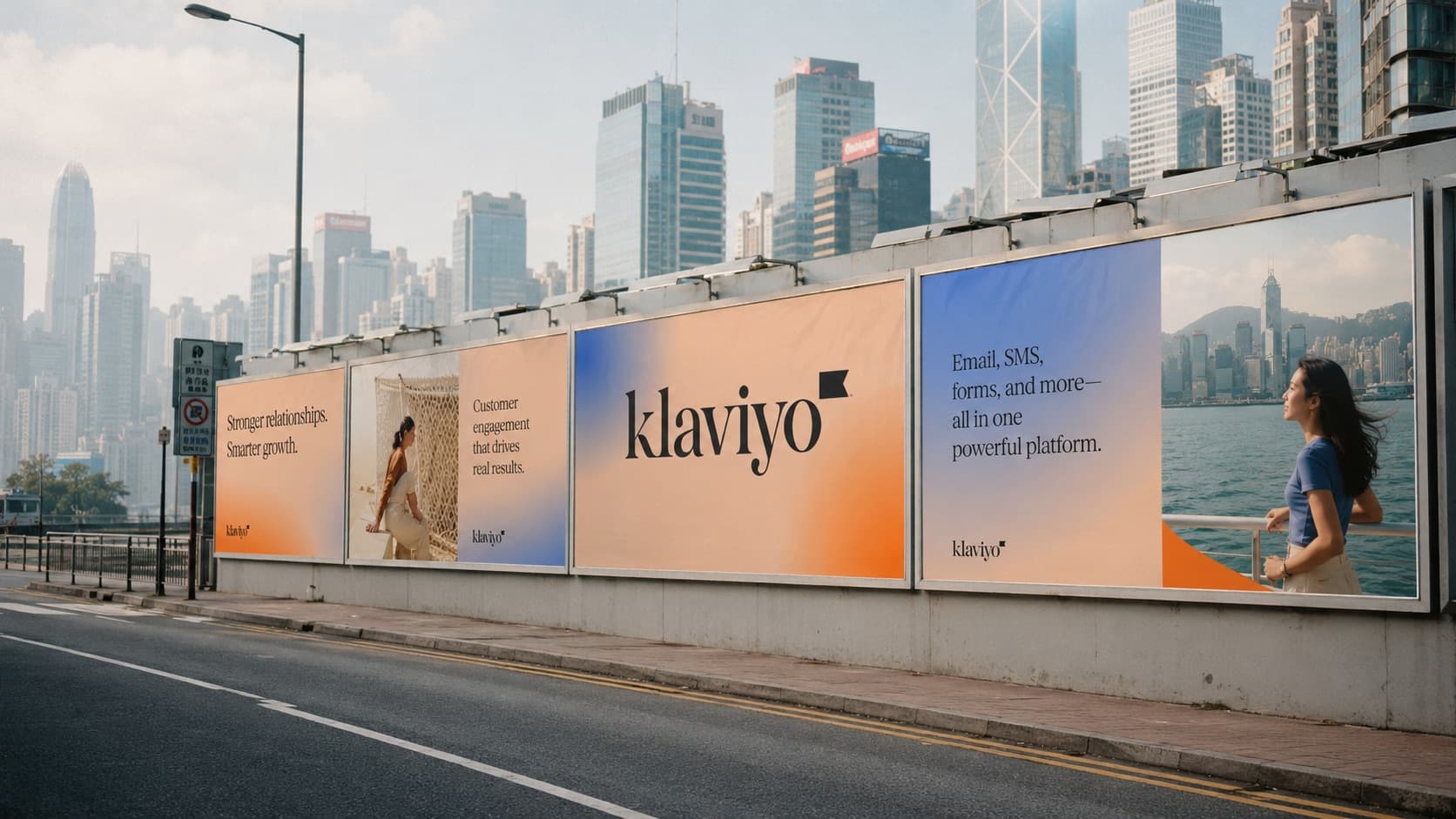 Klaviyo billboards along a Hong Kong harbourfront road, the Central skyline rising behind