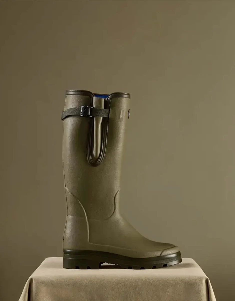 A single Le Chameau wellington boot on a draped plinth, olive on olive